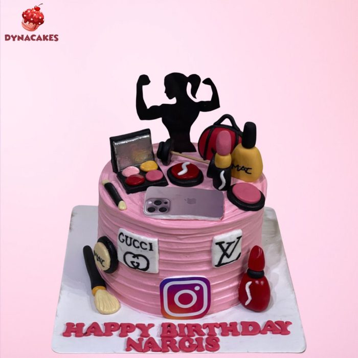 A pink Makeup and Gym Theme birthday cake in Karachi, decorated with gym silhouette topper, makeup items, luxury brand logos, and Instagram logo.