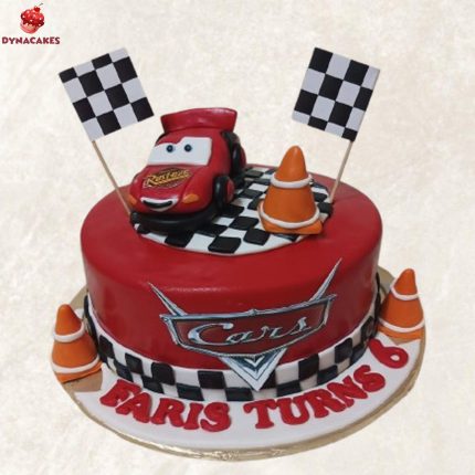 Red race car-themed birthday cake with checkered flags, cones, and custom topper for Faris's 6th birthday