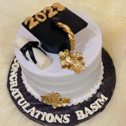 Graduation cake with cap, diploma, and gold 2023 decoration congratulating Basim