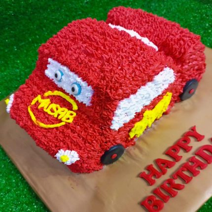 3D red McQueen race car-shaped birthday cake with custom name Musab for a themed birthday celebration