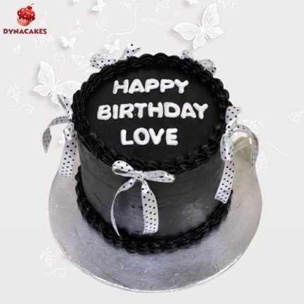 Black vintage cake with intricate design, decorated with floral accents and placed on a decorative cake stand in Karachi.