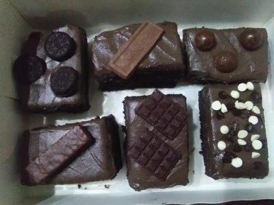 A box of assorted brownies with different flavors, including classic chocolate, walnut, and caramel, freshly baked by Dynacakes in Karachi.
