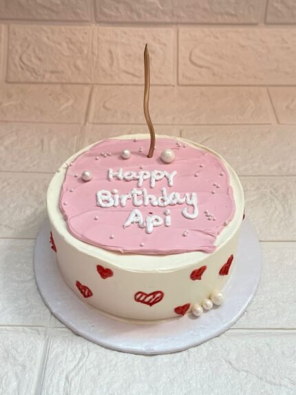 Pink Heart Bento Cake for Api with pink icing, red heart decorations, and a gold candle on top – DynaCakes Karachi